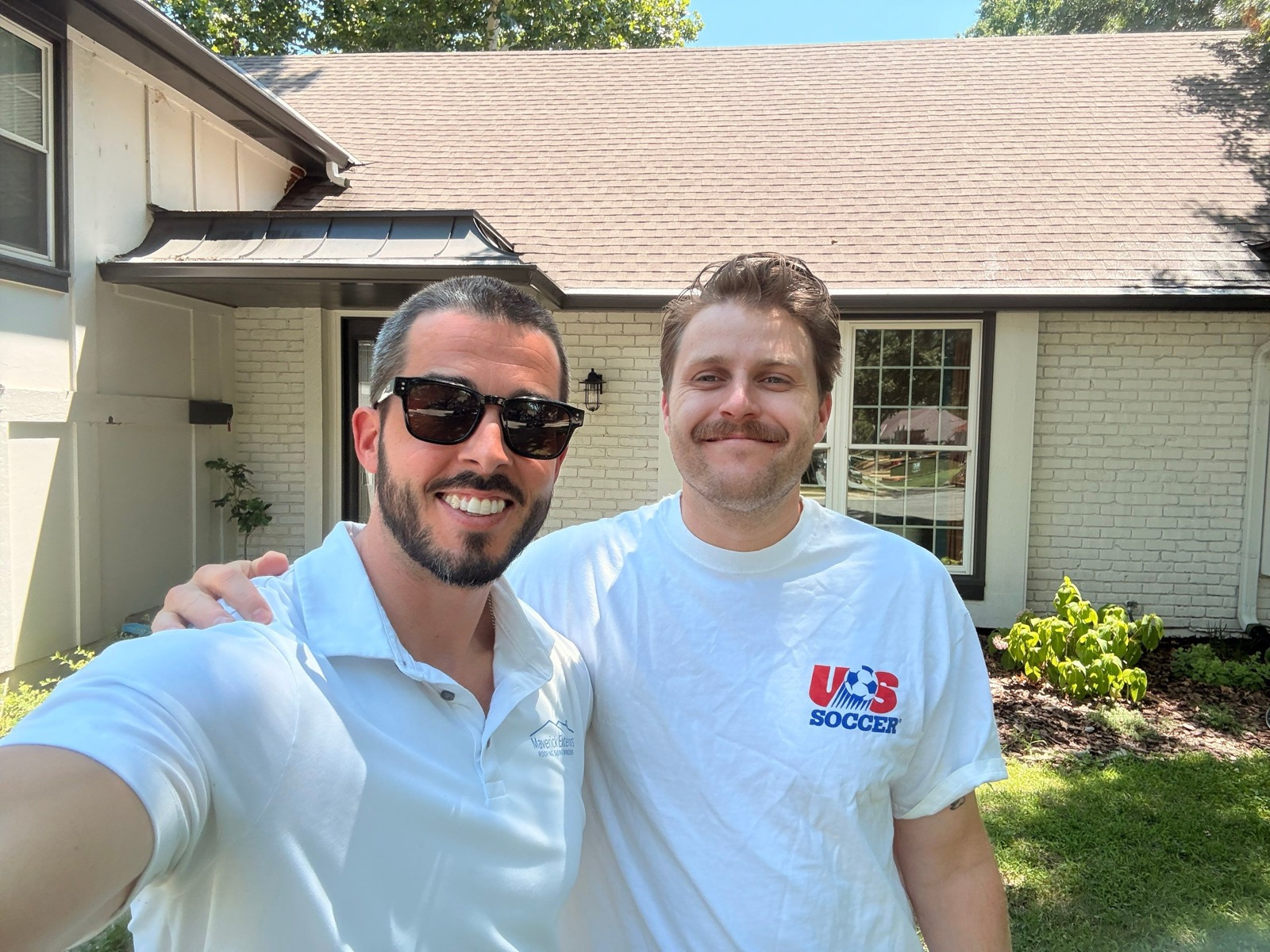 Maverick Exteriors team member with an Overland Park roofing customer in front of the home after a roof review.