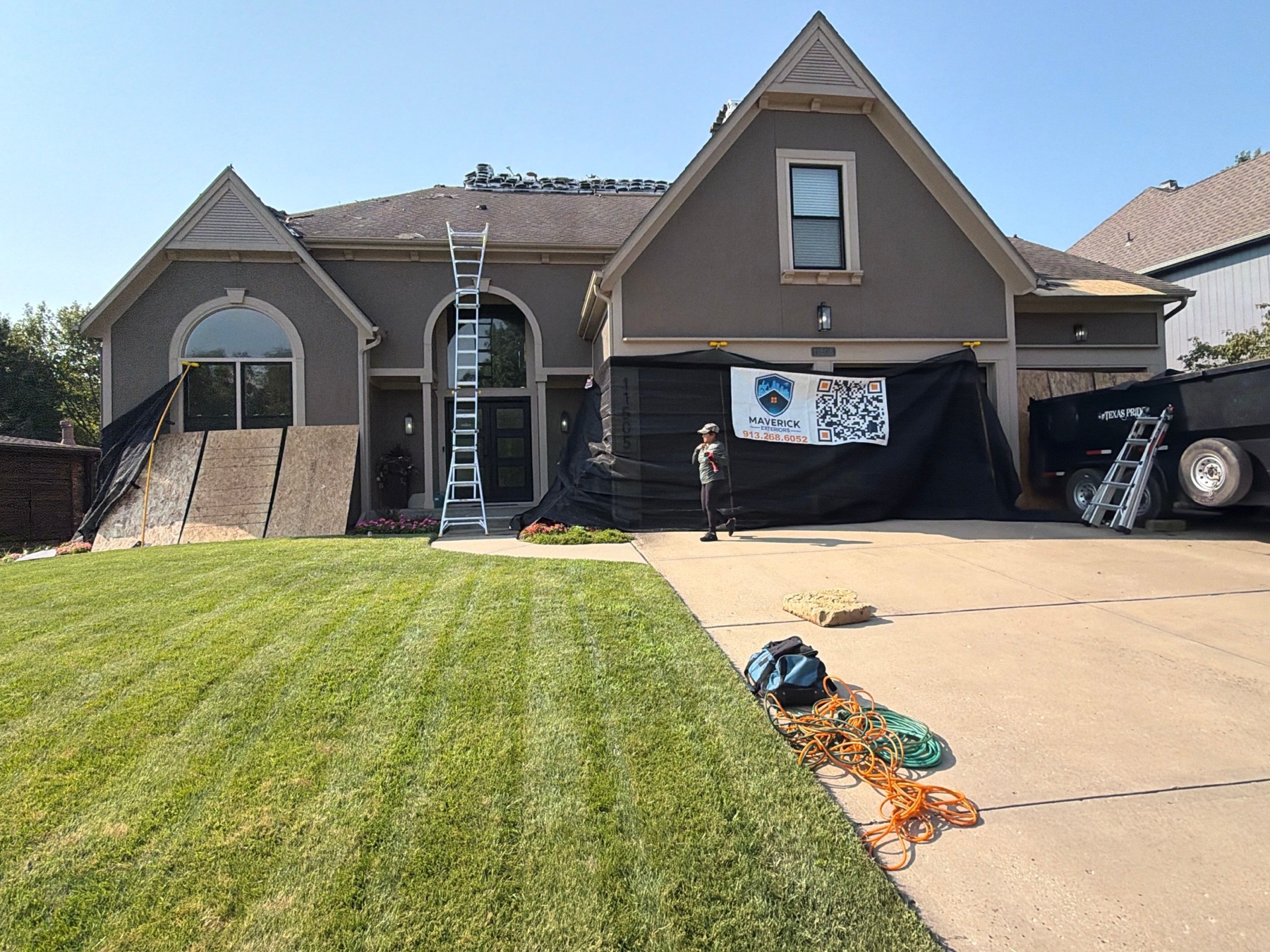 Plywood and catch-all protection installed around the front entry before roof replacement work.